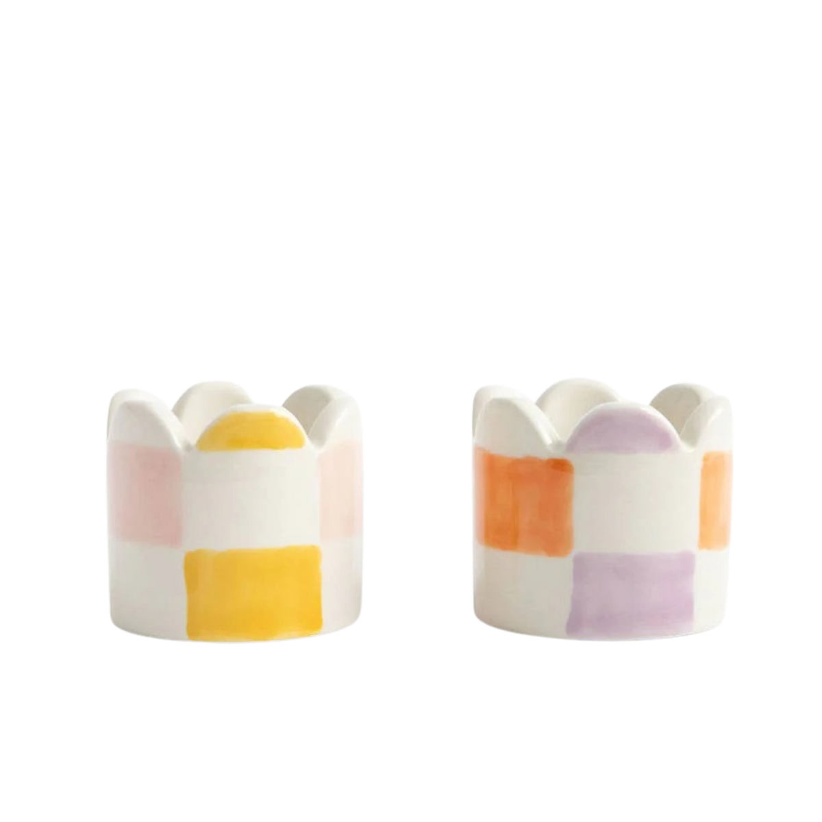 Two ceramic egg cups with colorful striped design on a white background