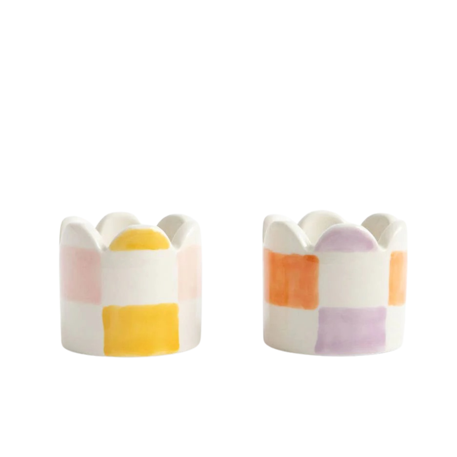 Two ceramic egg cups with colorful striped design on a white background