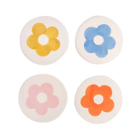 Four round coasters with colorful flower designs on a white background