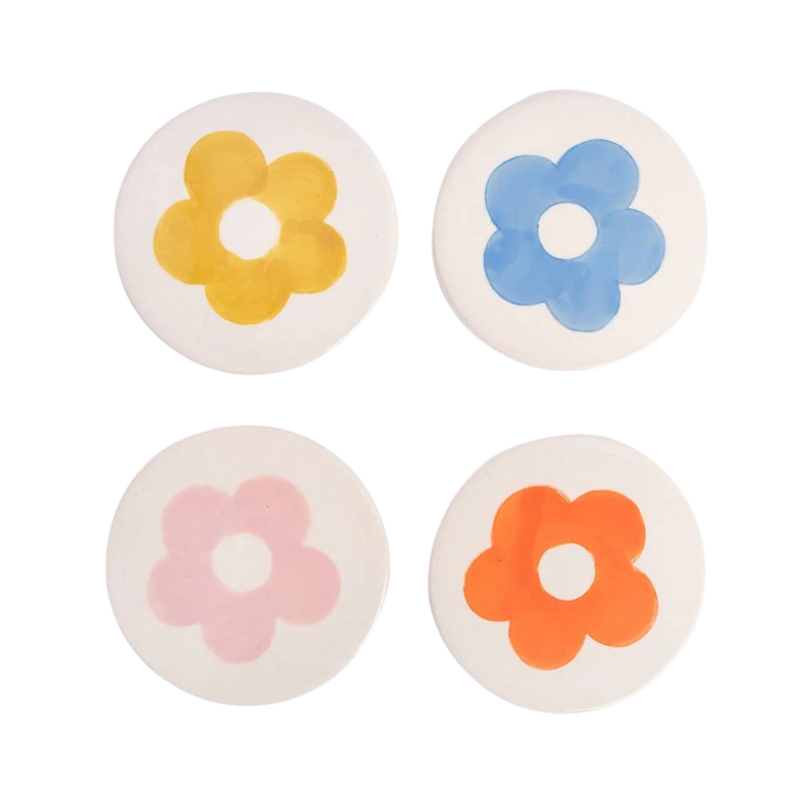 Four round coasters with colorful flower designs on a white background