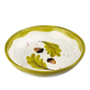 Ceramic bowl with green leaves and acorns on a white background
