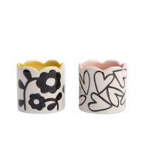 Two ceramic napkin rings with floral and heart designs on a white background