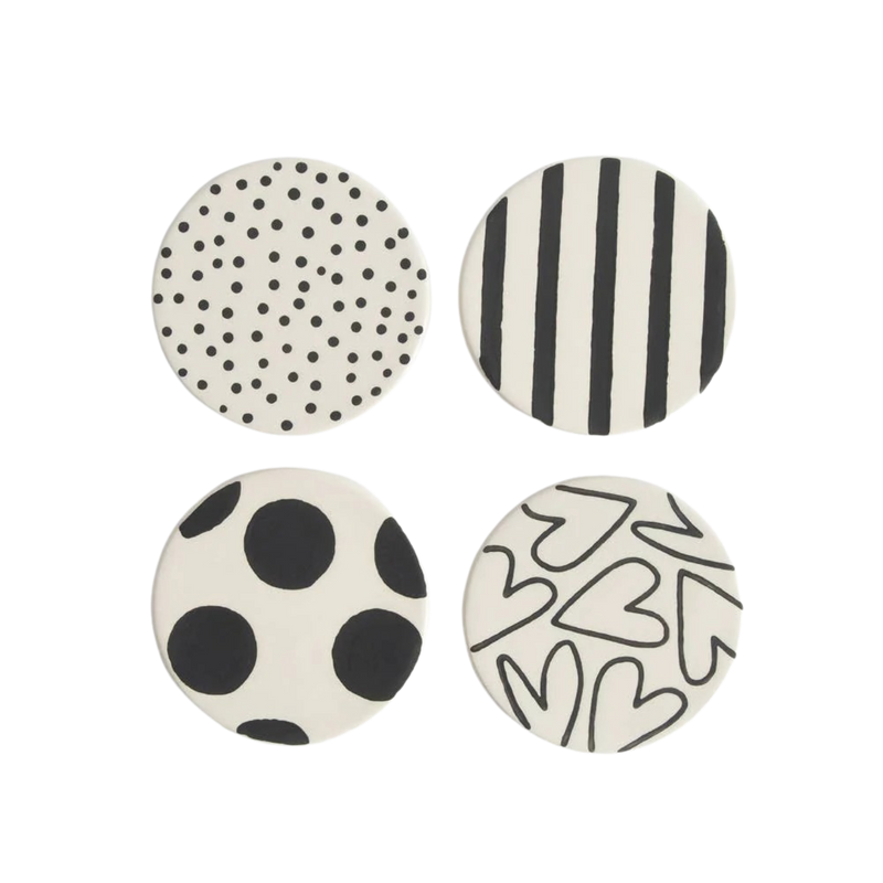 Four round coasters with black and white patterns on a white background