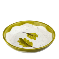 Ceramic bowl with green leaf design on a white background