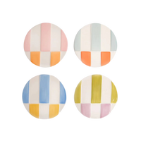 Four round ceramic coasters with colorful striped patterns on a white background