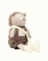 Stuffed toy resembling a bear in overalls on a white background