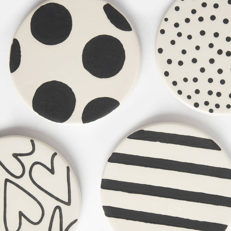 Set of ceramic coasters with black and white patterns on a white background