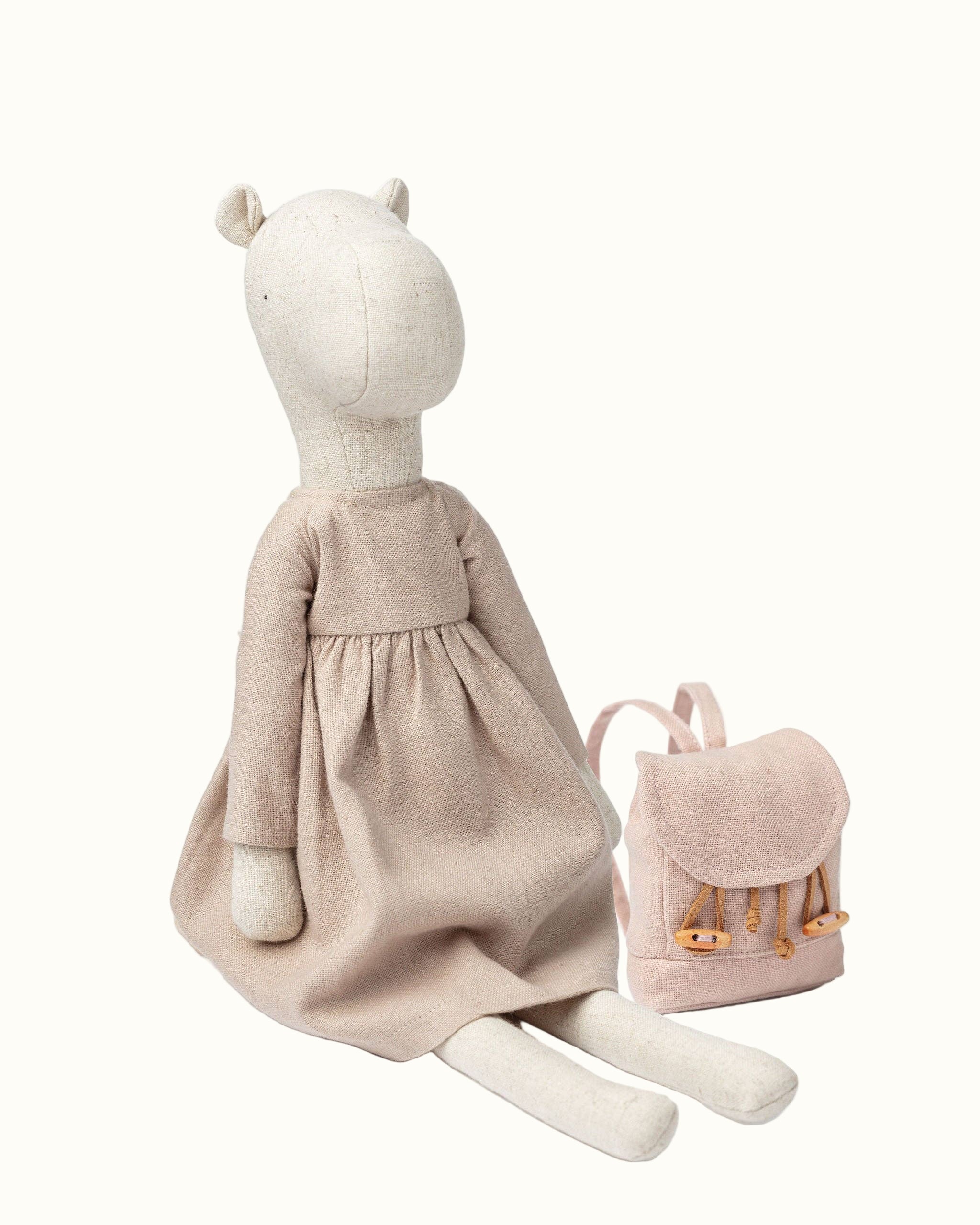Stuffed animal toy with a dress and backpack on a white background
