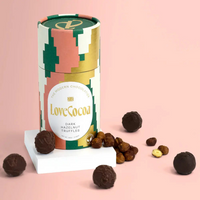 LoveCocoa dark hazelnut truffles in a colorful cylindrical box on a pink background