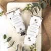 A tube of luxury hand cream with bee design next to matching packaging on a neutral background