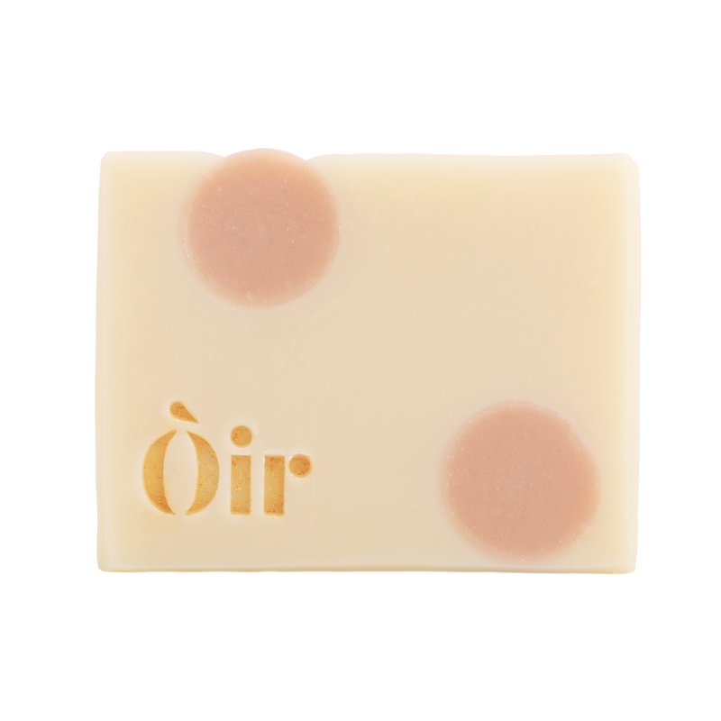 Bar of Oir Rose Geranium soap from the front on a white background. Beige bar, pink dot pattern and gold Oir logo.