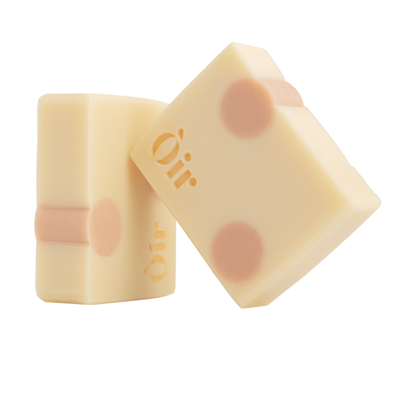 Two bars of hand and body soap with a delicate pattern on a white background, featuring the brand name 'Oir'.