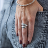 Hand wearing a silver ring with denim background