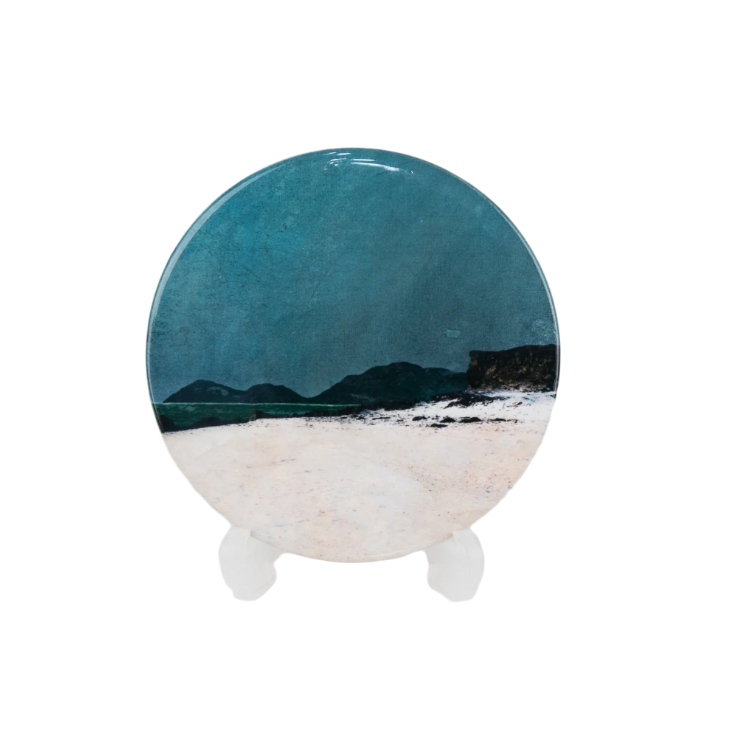 Round ceramic plate with a scenic design of mountains and water on a white background