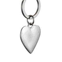 Silver heart-shaped keychain on a gray background