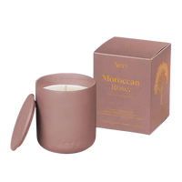 Pink candle with lid and matching box labeled 'Aery Moroccan Rose' on a white background