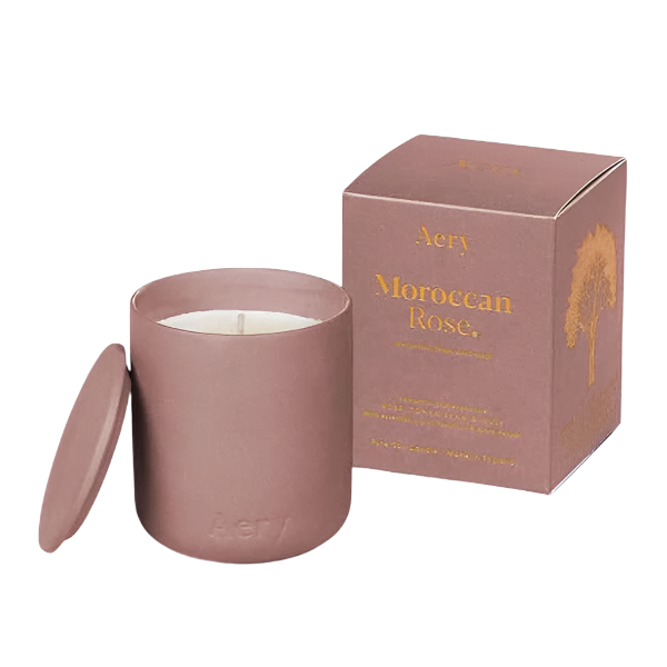 Pink candle with lid and matching box labeled 'Aery Moroccan Rose' on a white background