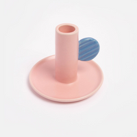 Pink and blue ceramic candlestick holder on a light gray background