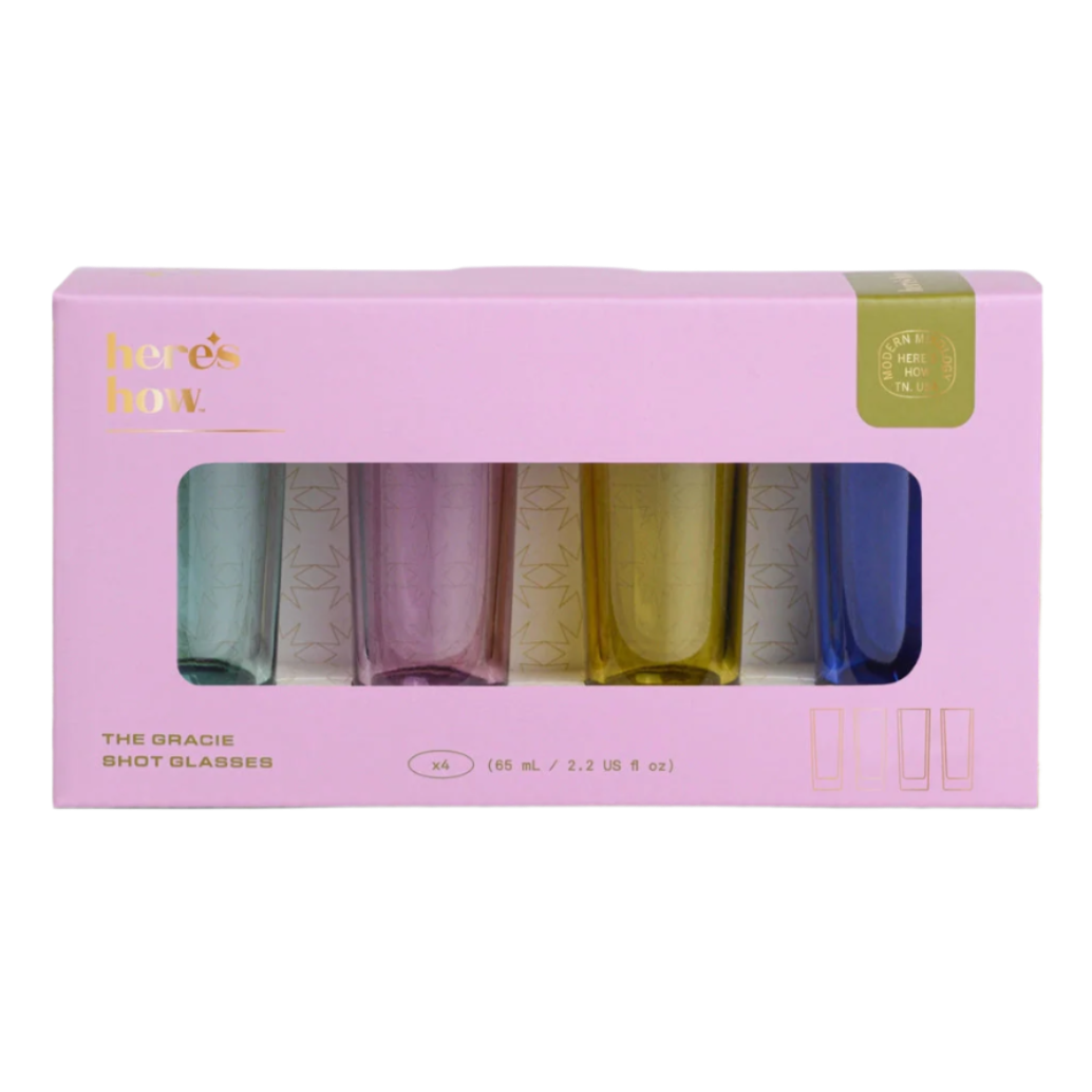 Set of 4 colourful shot glasses in a pink box with 'here's how' branding.