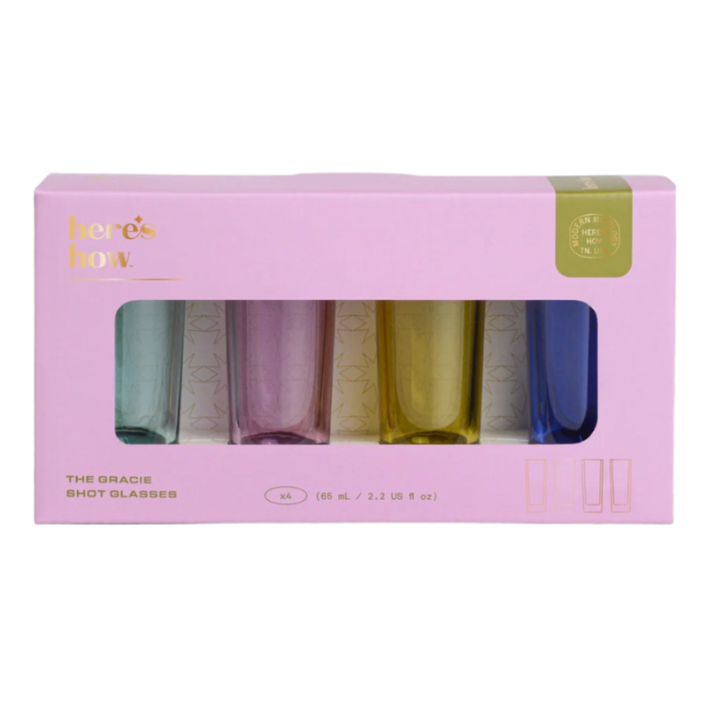 Set of 4 colourful shot glasses in a pink box with 'here's how' branding.