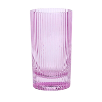 Pink glass tumbler with ribbed texture on a white background