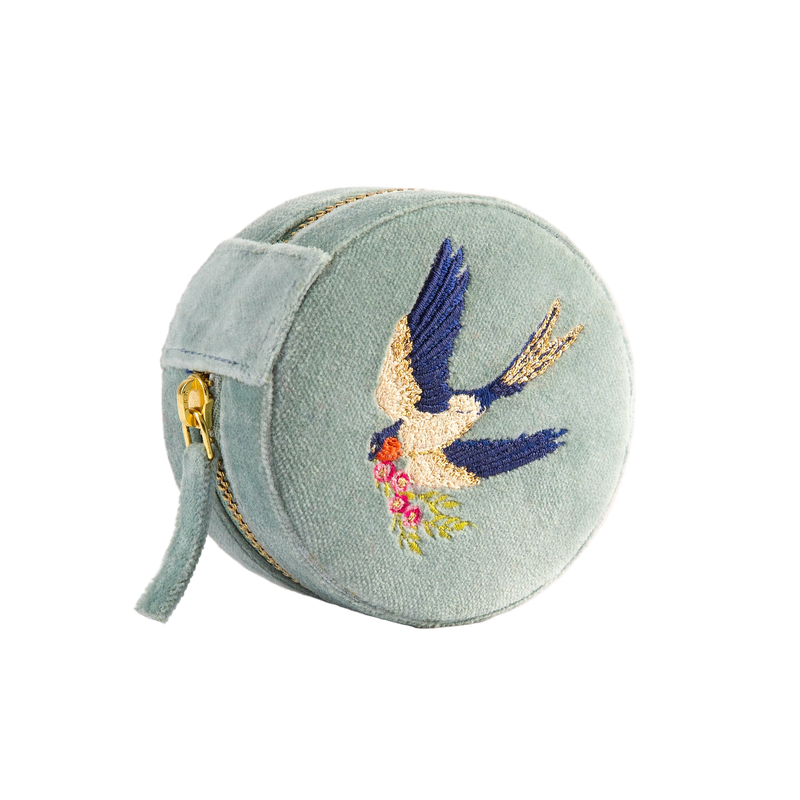Round embroidered purse with a bird design on a light green background