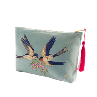 Light blue pouch with embroidered birds and a pink tassel on a white background