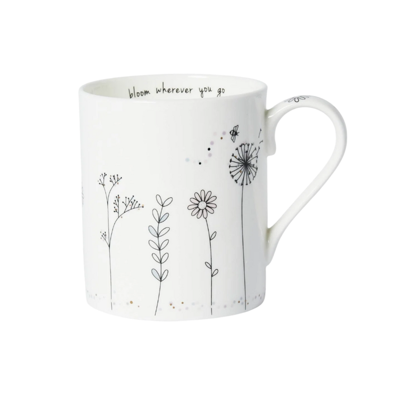 White mug with black floral illustrations and text on a white background